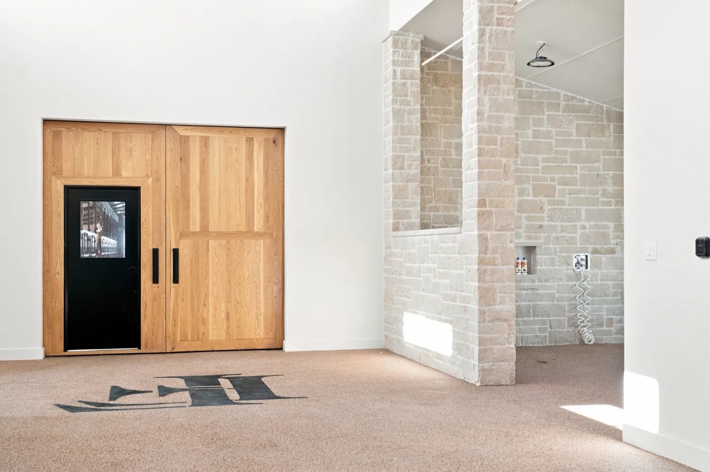 A stone wash rack inside the main barn, beside oak sliding doors.